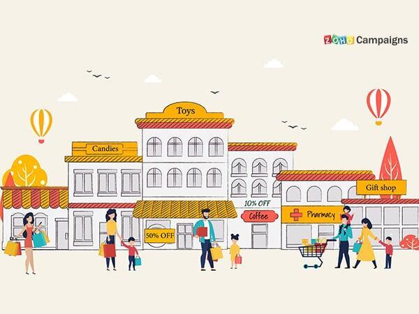 The image depicts a lively street scene of a shopping area with several stores. The buildings are illustrated in a cartoonish style with warm colors like yellow, orange, and white.